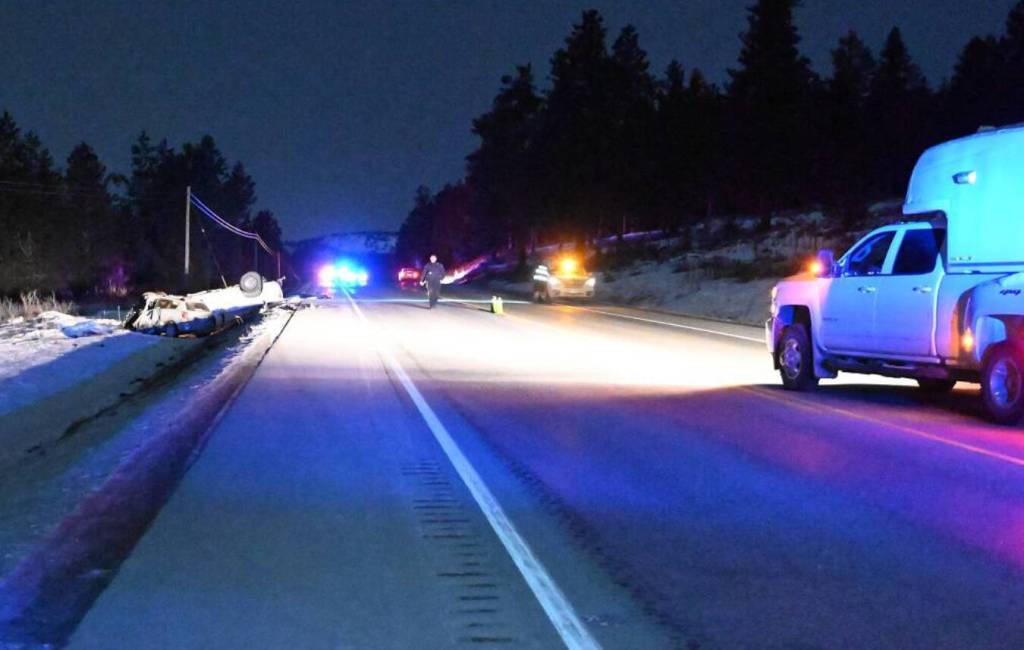 BC Highway Patrol vehicles and officers at the scene of a deadly crash on Highway #3/#93 between a white pickup and a grey Pontiac. (Photo courtesy BC Highway Patrol)